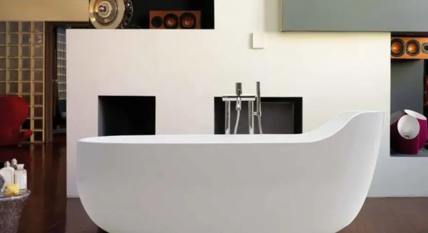 Una vasca da bagno bianca, simile a un globo, domina la scena. L'arredamento moderno include una parete con nicchie e un rubinetto cromato.