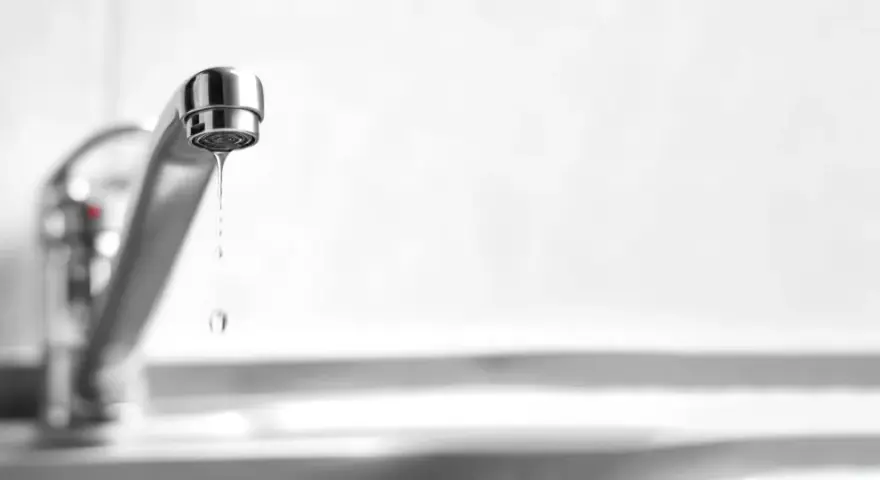 Un rubinetto perde acqua da sopra, goccia dopo goccia, uno spreco silenzioso.