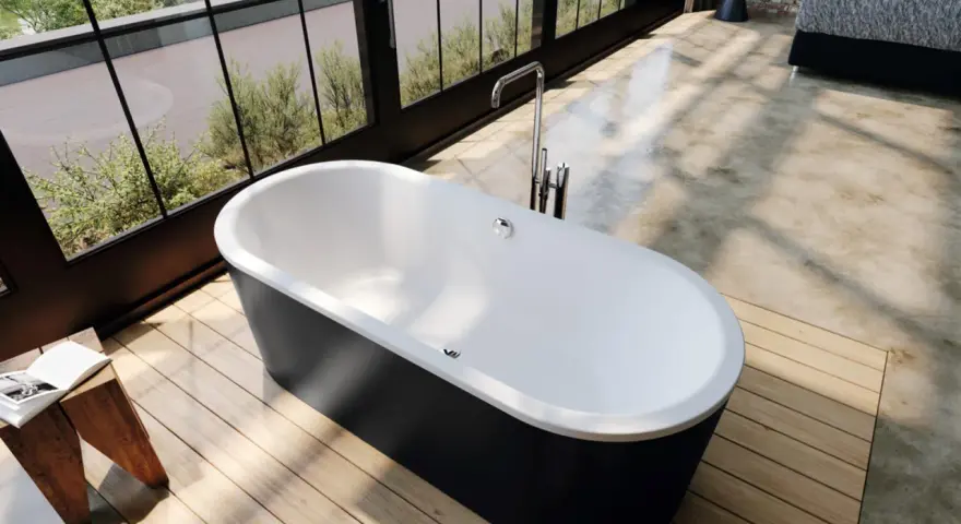 Vasca da bagno freestanding nera con rubinetteria cromata. Le misure della vasca da bagno sono ideali per un bagno moderno con vista sul giardino.