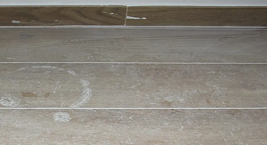 Stucco bianco residuo su piastrelle effetto legno. Ecco come togliere lo stucco dalle piastrelle per un risultato impeccabile.