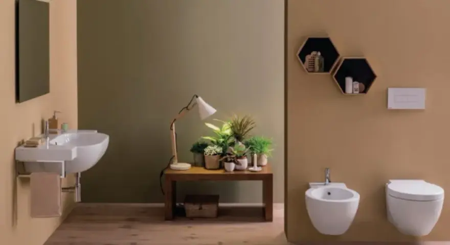 Bagno moderno con lavabo sospeso, bidet e vaso **ceramica globo**. Tavolino con piante e lampada.