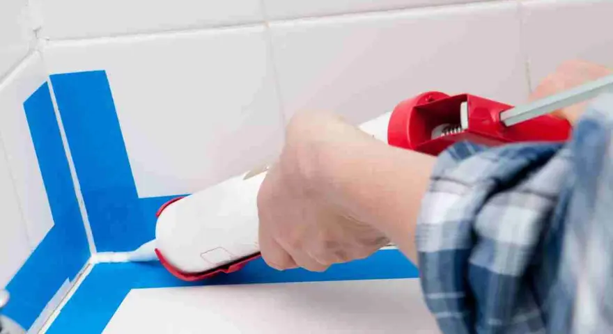 Applicazione sigillante per una doccia senza piatto, impermeabilizzazione perfetta con nastro blu.