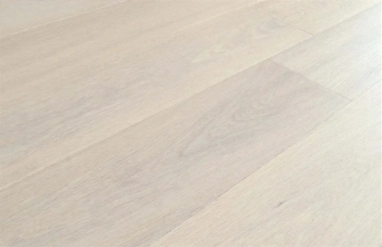 Dettaglio di un pavimento in legno chiaro, con venature delicate. Lo spessore del parquet prefinito è ideale per un look moderno e raffinato.
