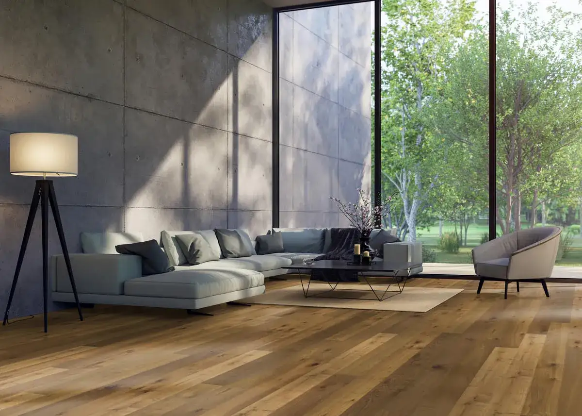 Soggiorno moderno con parquet spazzolato, divano angolare grigio, poltrona e grande finestra con vista sul verde.