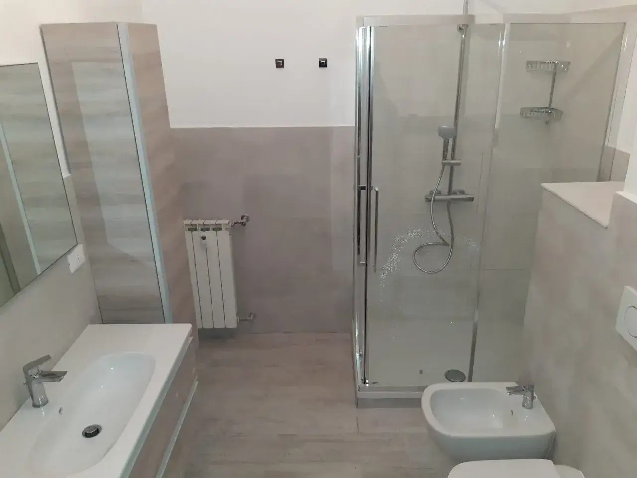 Bagno ristrutturato con doccia, bidet e lavabo. Sostituzione tubature bagno manutenzione straordinaria completata.