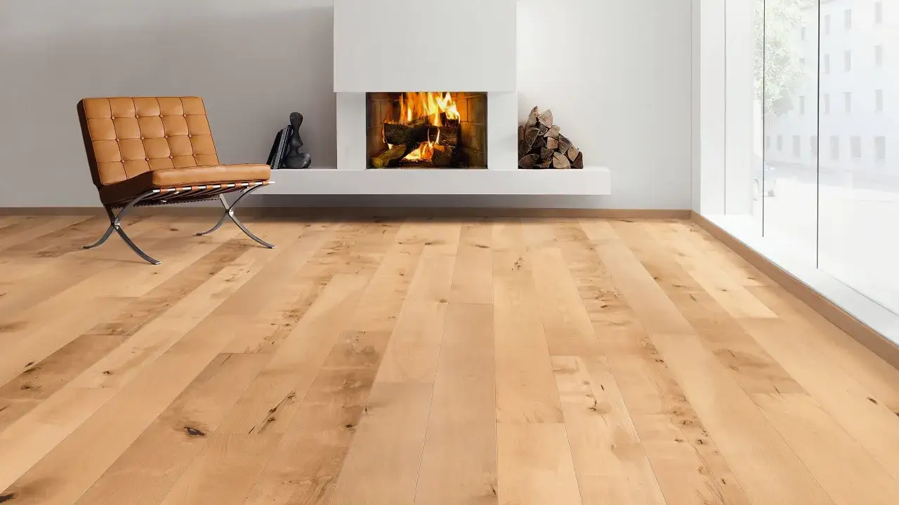 Un accogliente soggiorno con camino acceso, una poltrona in pelle e un caldo parquet faggio naturale che illumina la stanza.