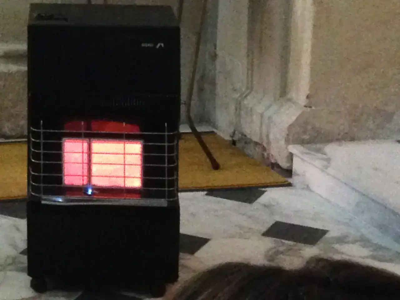 Stufa a gas nera con piastre incandescenti rosse, che dimostra come le stufe a gas sono sicure per riscaldare gli ambienti.