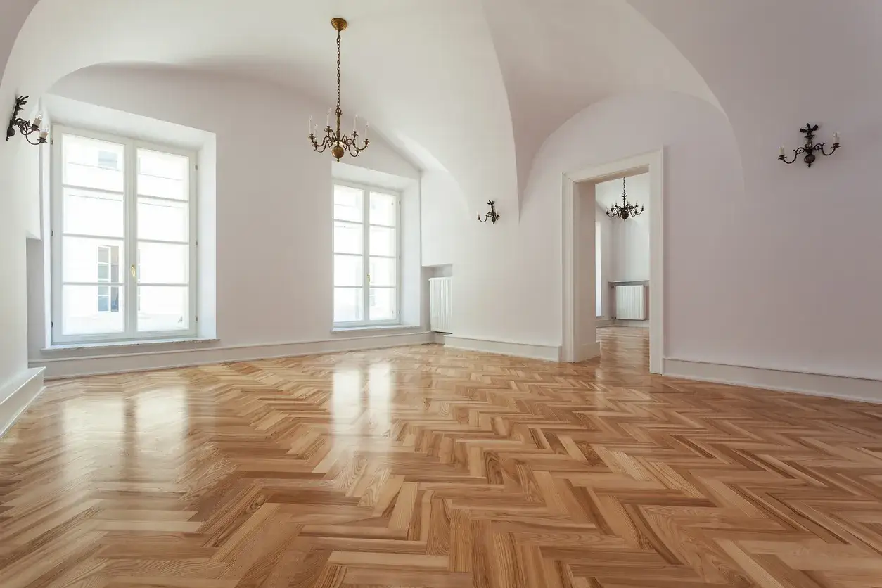 Parquet a spina di pesce lucido, pronto per la levigatura parquet prima o dopo imbiancatura. Stanze luminose con grandi finestre e lampadari antichi.