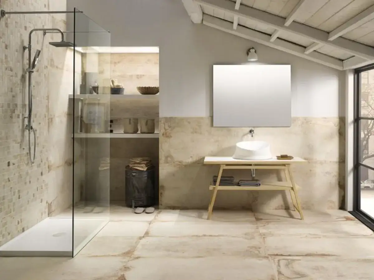 Bagno moderno con doccia walk in dimensioni ideali, lavabo minimalista e finiture in pietra.