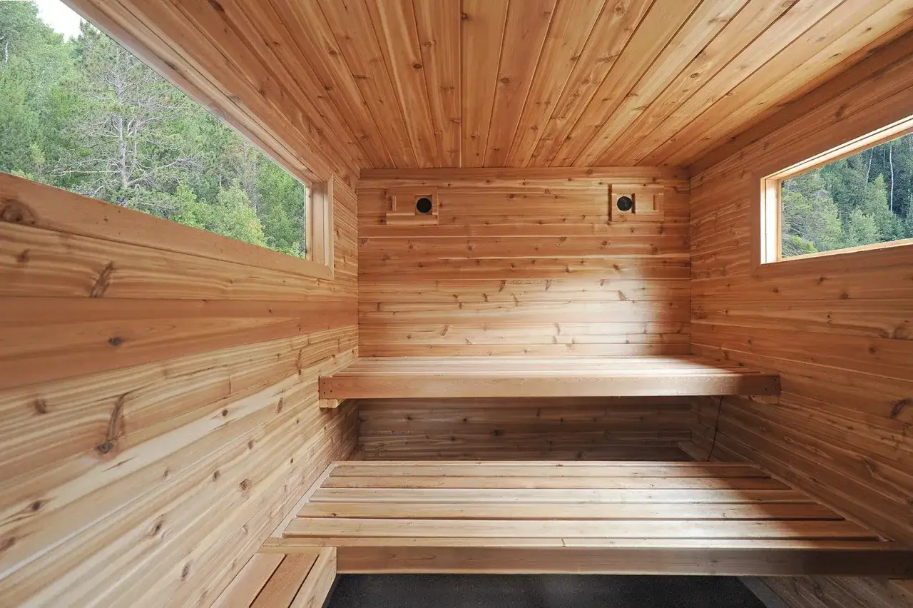 Interno di una sauna in legno con panche, finestre e prese d'aria. Un esempio di come costruire una sauna.