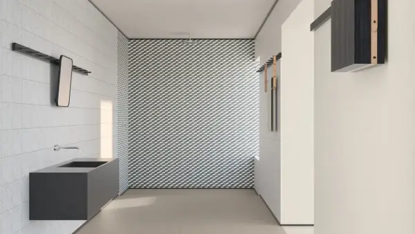 Bagno moderno con lavabo sospeso e parete con motivo geometrico. I **mutina rivestimenti** creano un ambiente di design.